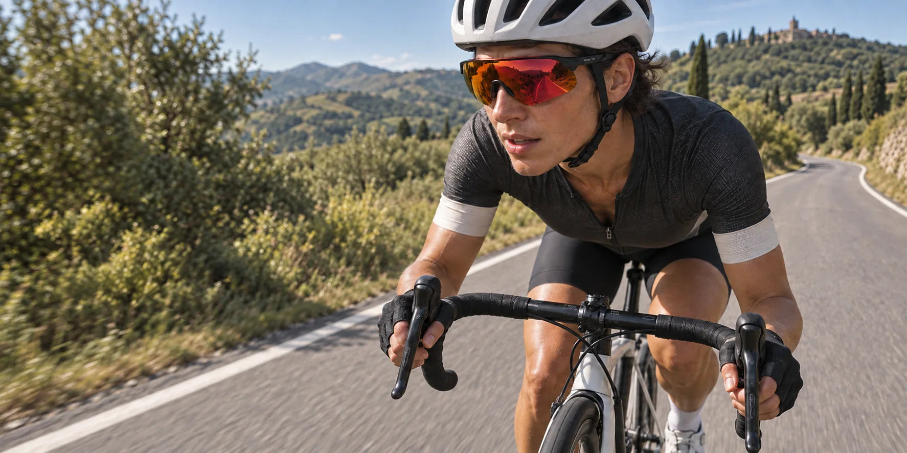 Cyclist wearing mirrored sport sunglasses and a helmet on a countryside road